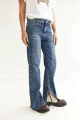 Pantalón de jean azul con efecto lavado, corte recto y tajo en la pierna.