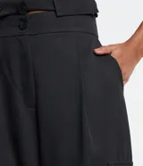 Pantalón de vestir negro, de corte recto, con bolsillos cargo laterales, cintura lisa y pliegues delanteros.