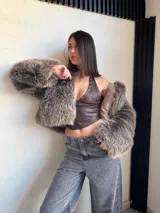Campera corta color marrón con detalles de piel sintética en mangas y cuello.