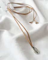 Choker con dije en forma de concha, hecho de material sintético y cordón color camel.