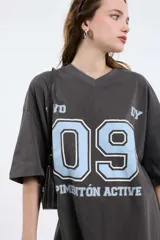 Remera color beige con cuello en V y estampado con la palabra 'Authentic' y una estrella.