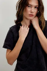 Remera blanca de algodón, semicorta y encogida, con corte holgado, mangas cortas y cuello redondo.