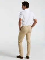 Pantalón chino color beige, con bolsillos delanteros diagonales, cierre y botón en la cintura. Logo bordado a tono.