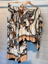 Pantalón ancho de satén con cintura elástica y estampado de motivos florales y cadenas en tonos marrones, beige y dorado sobre fondo blanco. Presenta un borde inferior con detalles en color turquesa.