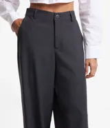 Pantalón de vestir gris oscuro, de corte recto, con bolsillos laterales y botón en la cintura.