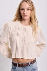 Blusa color crudo de manga larga con detalles de puntilla.