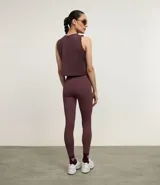 Legging deportiva ajustada al cuerpo, color morado oscuro, con cintura alta y bolsillo pequeño en la espalda.
