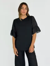 Blusa negra de algodón con mangas cortas de gasa con volados.