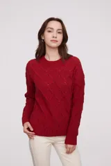 Sweater de punto color mostaza, con diseño de trenzas y puños acampanados.