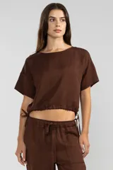 Top color marrón chocolate de lino y tencel, con mangas cortas, escote redondo y lazo ajustable en el ruedo.