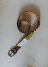 Cinturón de cuero marrón con detalle de aguayo multicolor. Hebilla metálica plateada.