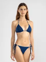 Top de bikini triángulo confeccionado en lurex brillante con terminaciones en overlock. Cuenta con tiras ajustables en cuello y espalda, finalizadas con los dijes insignia de Polonio.
