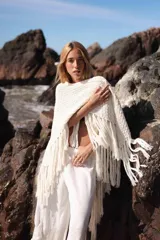 Triángulo de lana tejido a mano, color crudo, con flecos largos en todo el borde.