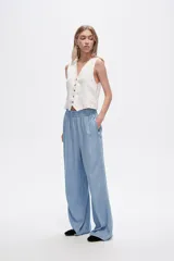 Pantalón azul de lyocell, de corte ancho y tiro alto, con cintura elastizada y bolsillos laterales.