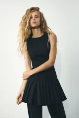 Vestido marrón sin mangas con cuello redondo y falda con pliegues.