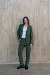 Pantalón verde con finas rayas verticales blancas, corte recto, tiro alto y bolsillos laterales.