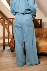 Pantalón denim gris con efecto lavado y detalles de pedrería en el frente, de corte amplio.