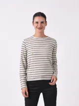 Remera de manga larga con cuello redondo y estampado de rayas horizontales finas. Presenta un detalle distintivo de botones decorativos dispuestos en una línea diagonal que desciende desde el hombro hacia el pecho.