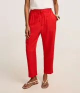 Pantalón femenino de corte fluido, color rojo vibrante, con cintura elástica ajustable mediante lazo y bolsillos laterales.