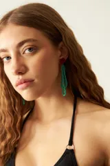 Aros colgantes con forma de flor roja y cuentas de vidrio color verde esmeralda.