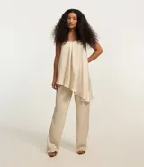 Pantalón recto color beige, confeccionado en crepé texturizado con cintura elástica y corte suelto.