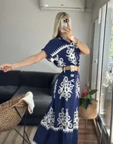 Vestido camisero largo negro con estampado de flores blancas y cinto incluido.