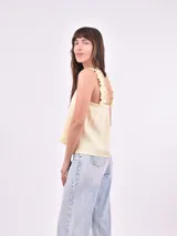 Blusa sin mangas color amarillo pálido, con breteles anchos con volados y escote cuadrado.