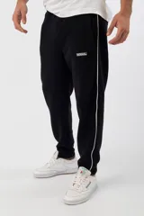 Jogging negro estilo retro, confeccionado en algodón y poliéster, con bolsillo y diseño deportivo.