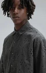 Camisa de manga corta, corte oversize, color negro con efecto desgaste. Confeccionada en algodón bordado (broderie) con diseño floral y calado.