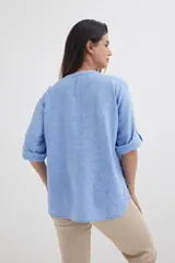 Camisa color crema de algodón con escote en V, mangas 3/4 con trabilla y dos bolsillos con solapa en el pecho.