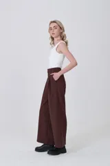 Pantalón de poliéster color marrón oscuro, de tiro alto, corte ancho y pinzas frontales.