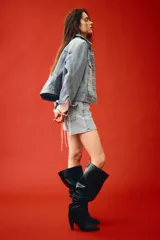 Campera trucker corta de denim celeste, con cuello clásico, cierre frontal con botones metálicos, mangas largas con puños abotonados, bolsillos superiores con solapa y botón, bolsillos laterales y trabillas ajustables con botones en los laterales del bajo.