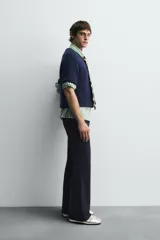 Cárdigan azul marino de manga corta tejido en hilatura con lana y alpaca, de textura suave. Tiene cuello redondo, rib en los bordes y cierre frontal con botones. Edición especial Harry Lambert for Zara x Disney.