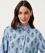Camisa celeste de viscolino con estampado floral, cuello camisero y mangas largas.
