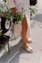 Sandalias de cuero negras con diseño de tiras cruzadas y detalle de elástico en el talón.