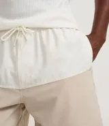 Bermuda de baño masculina confeccionada en microfibra, con cintura elástica, cordón ajustable, bolsillos laterales y trasero con cremallera, y estampado bicolor.