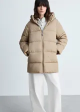 Campera puffer color beige con capucha, cierre frontal con cremallera y bolsillos laterales.