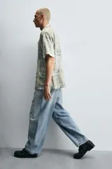 Pantalón de jean celeste con lavado gastado, corte holgado y roturas en ambas piernas.