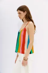 Top de viscosa con estampado a rayas multicolores, calce holgado y elástico en la espalda. Presenta breteles trenzados en distintos tonos.