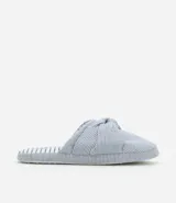 Pantufla abierta con rayas verticales azules y blancas, y nudo decorativo en la parte superior.