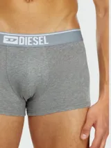 Pack de tres bóxers Diesel, uno gris liso con pretina gris claro con logo, y dos con estampados.