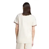 Remera Adidas color beige con cuello redondo y mangas cortas con ribete marrón. Presenta las tres rayas características de la marca en color marrón en los hombros y el logo bordado en el pecho.