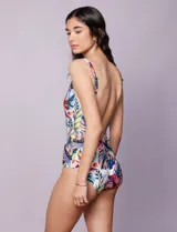 Malla enteriza estampada con motivos florales y hojas en tonos azules, rojos, amarillos y verdes. Escote en V cruzado y breteles regulables.