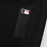 Short deportivo negro con cintura elástica ajustable con cordón, bolsillos laterales con cierre y logo de los Yankees estampado en la pierna izquierda.