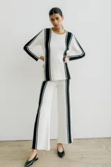 Sweater de punto color blanco con rayas verticales negras y cuello redondo color beige.