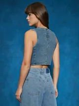 Chaleco de jean celeste con botones metálicos.