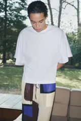 Camiseta blanca de algodón con cuello redondo y mangas cortas tipo capa.