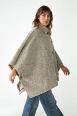 Capa con cuello, cierre frontal con botones y bolsillos delanteros. Confeccionada en lana fina sin teñir, diseñada exclusivamente por Don Baez.