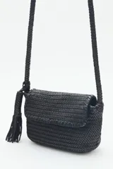 Cartera bandolera negra de cuero vacuno trenzado, con acceso superior con cierre metálico, interior forrado con bolsillos y correa de hombro trenzada.
