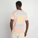 Camiseta rosa pálido de manga corta con cuello redondo y estampado pequeño en el pecho con la palabra "Oranges".